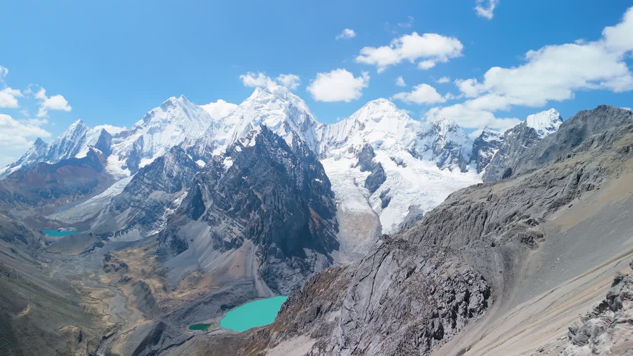 Sweeping aerial panorama from San Antonio Pass showcases dramatic Cordillera Huayhuash with its towering snowy peaks - Yerupajá, Siula Grande, Sarapo, Carnicero, Rasac and turquoise glacial lakes
