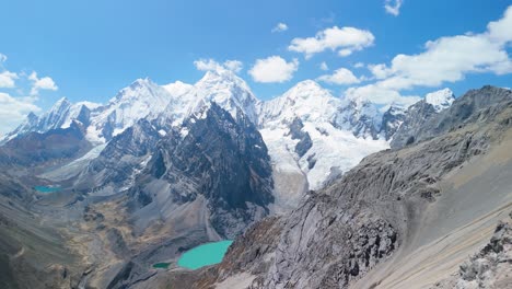 sweeping aerial panorama from san antonio pass showcases dramatic cordillera huayhuash with its towering snowy peaks - yerupajá, siula grande, sarapo, carnicero, rasac and turquoise glacial lakes