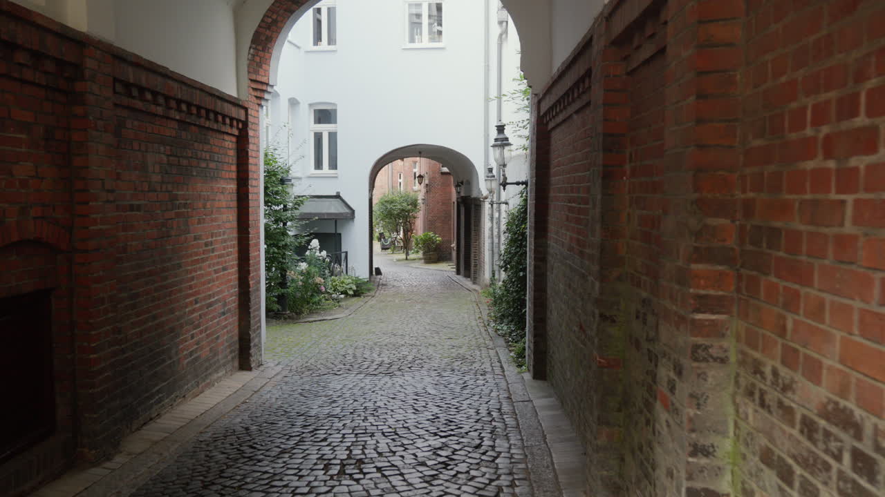 A charming alleyway with brick walls and an archway.