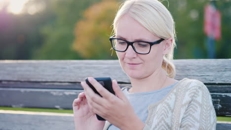 woman using smartphone on a bench