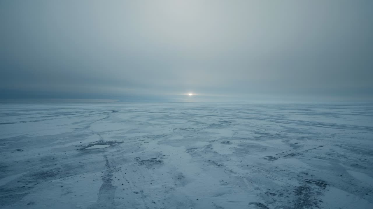 Hitaasti liikkuva kamera paljastaa horisontissa olevan jäätyneen meren tasangon, aurinko kirkastuu ja paljastaa karkean jään