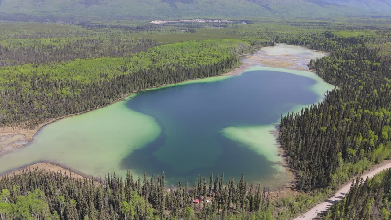 Drone footage of deforestation in the Canadian forest. River running next to the mountains in a village of indiginous tribes