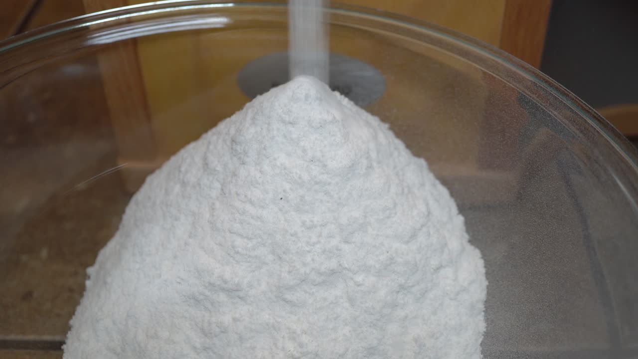 la harina de arroz que se muele en una fresadora se acumula en un recipiente de vidrio para hornear sin gluten