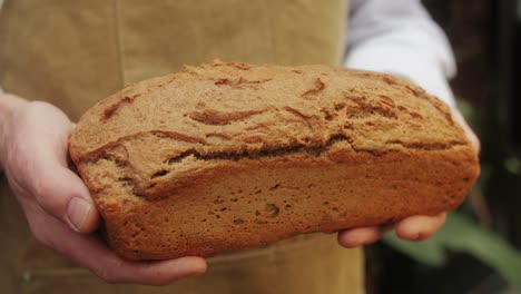 the baker holds in hands a of fresh bread close-up. artisan bread is making by skill bakers using natural and high-quality ingredients. food with health and flavour benefits.