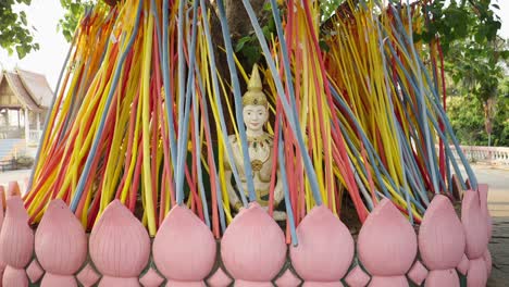 colorful ribbons adorning a buddhist statue at a temple