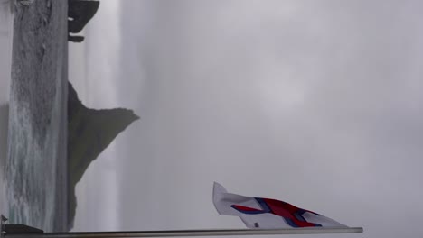 Blick-Auf-Drangarnir-Und-Tindholmur-Von-Einem-Boot-Mit-Einer-Färöischen-Flagge-An-Der-Seite