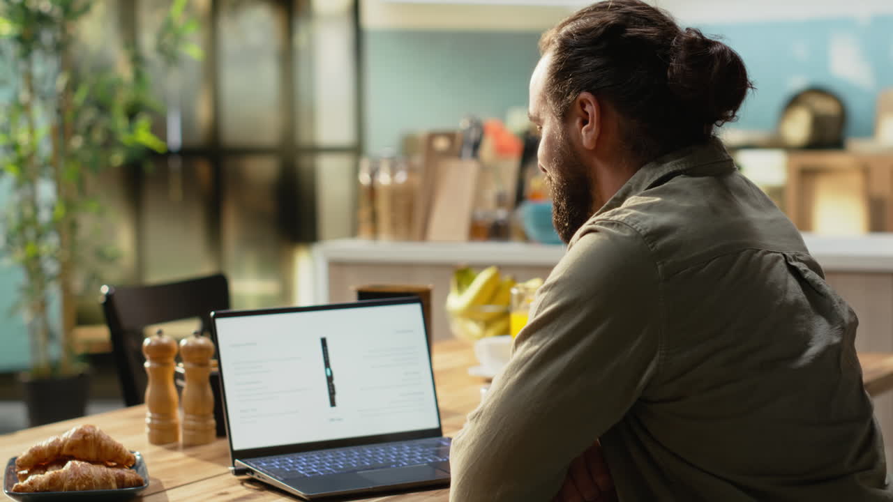 Casual man looking at new phone product announcement on laptop