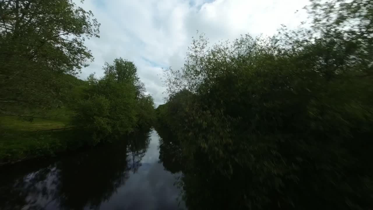 drone flying just above a pond lake, black water reflection, FPV takes rise to the air to a landscape overview, rural meadows of France, Hyeres Valley in Britain Provence
