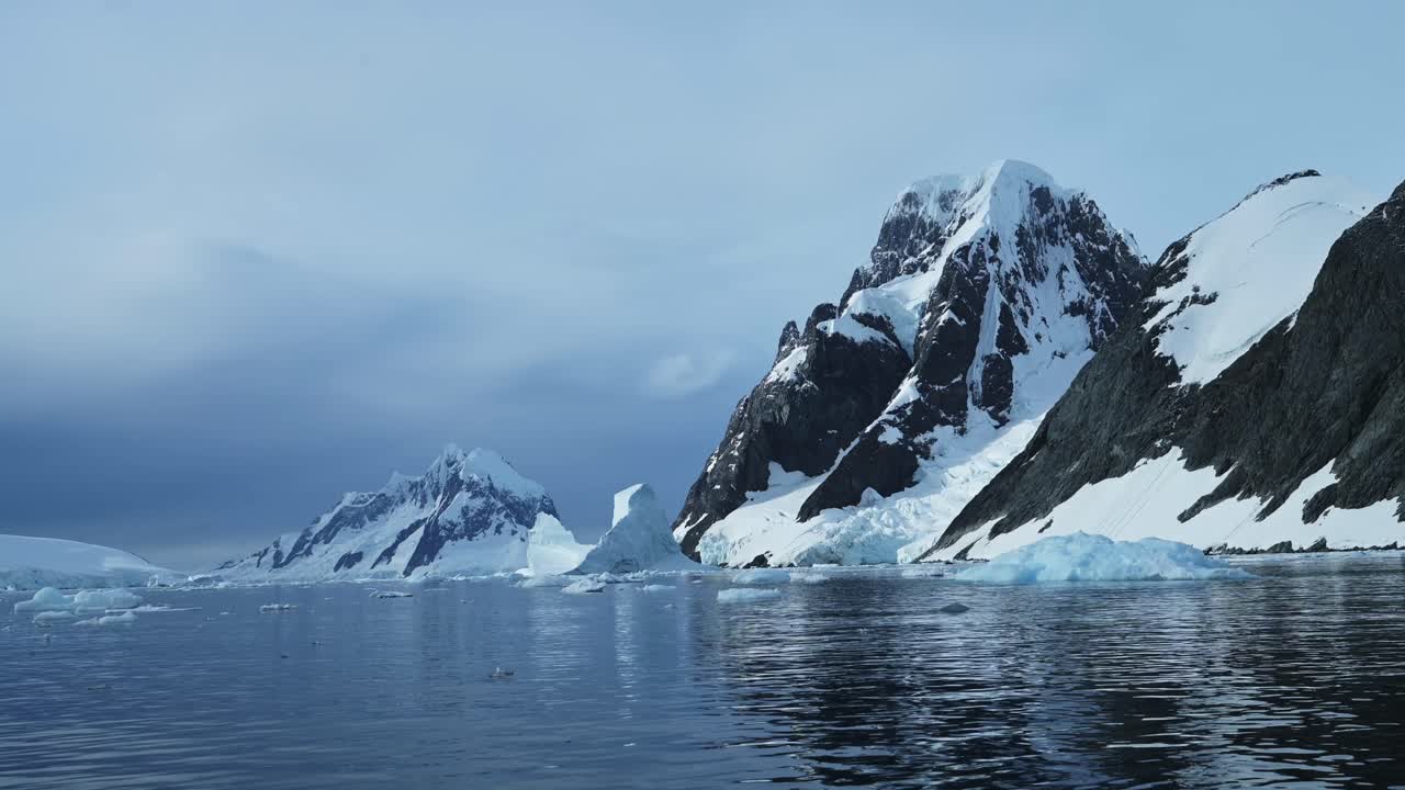 Global Warming and Climate Change with Melting Ice and Warming Ocean in Antarctica, Mountains and Winter Scenery on Antarctic Peninsula in Beautiful Dramatic Coastal Scene