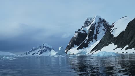 Global-Warming-and-Climate-Change-with-Melting-Ice-and-Warming-Ocean-in-Antarctica,-Mountains-and-Winter-Scenery-on-Antarctic-Peninsula-in-Beautiful-Dramatic-Coastal-Scene