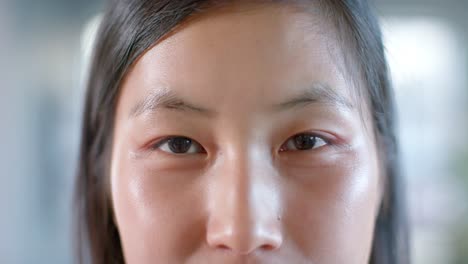 portrait close up of happy asian businesswoman at office, smiling in slow motion