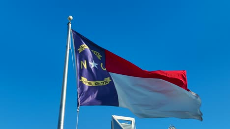 North-Carolina-flag-waving-against-bright-blue-sky