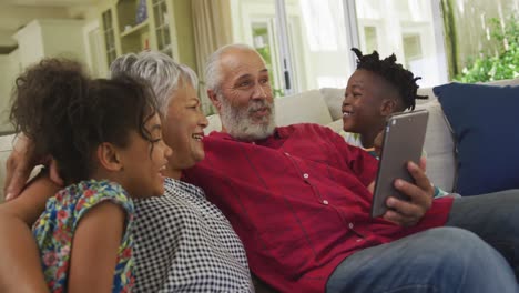 grandparents and grandchildren using digital tablet at home