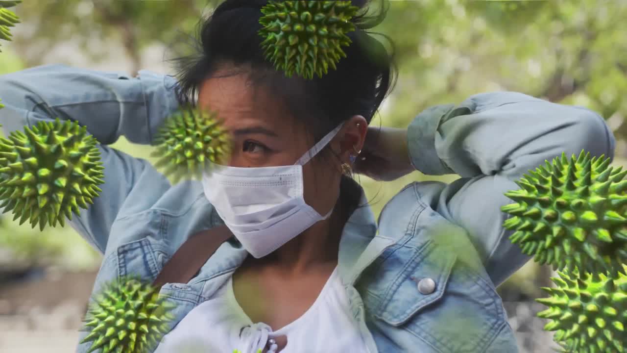 Animation of macro coronavirus Covid-19 cells spreading over a mixed race woman wearing a face mask