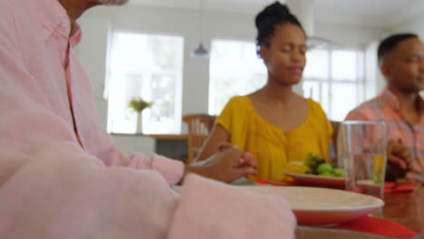 Multi-generation-black-family-praying-together-at-dining-table-in-comfortable-home-4k