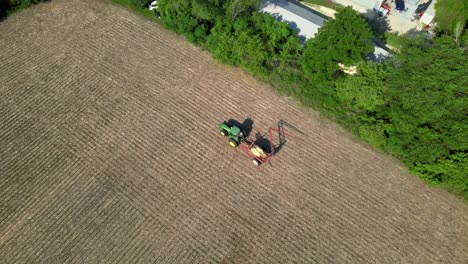 farm sprayer tractor with boom folding at the field after work