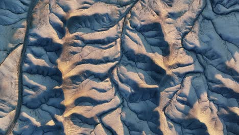 Sunset-dry-riverbeds-on-grey-mountain-range-in-Utah,-Grand-Canyon,-aerial-orbit