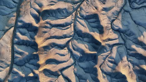 sunset dry riverbeds on grey mountain range in utah, grand canyon, aerial orbit