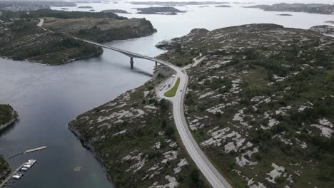 cars driving on road in øygarden, norway near bergen with beautiful landscape and cars driving over svelgen bridge