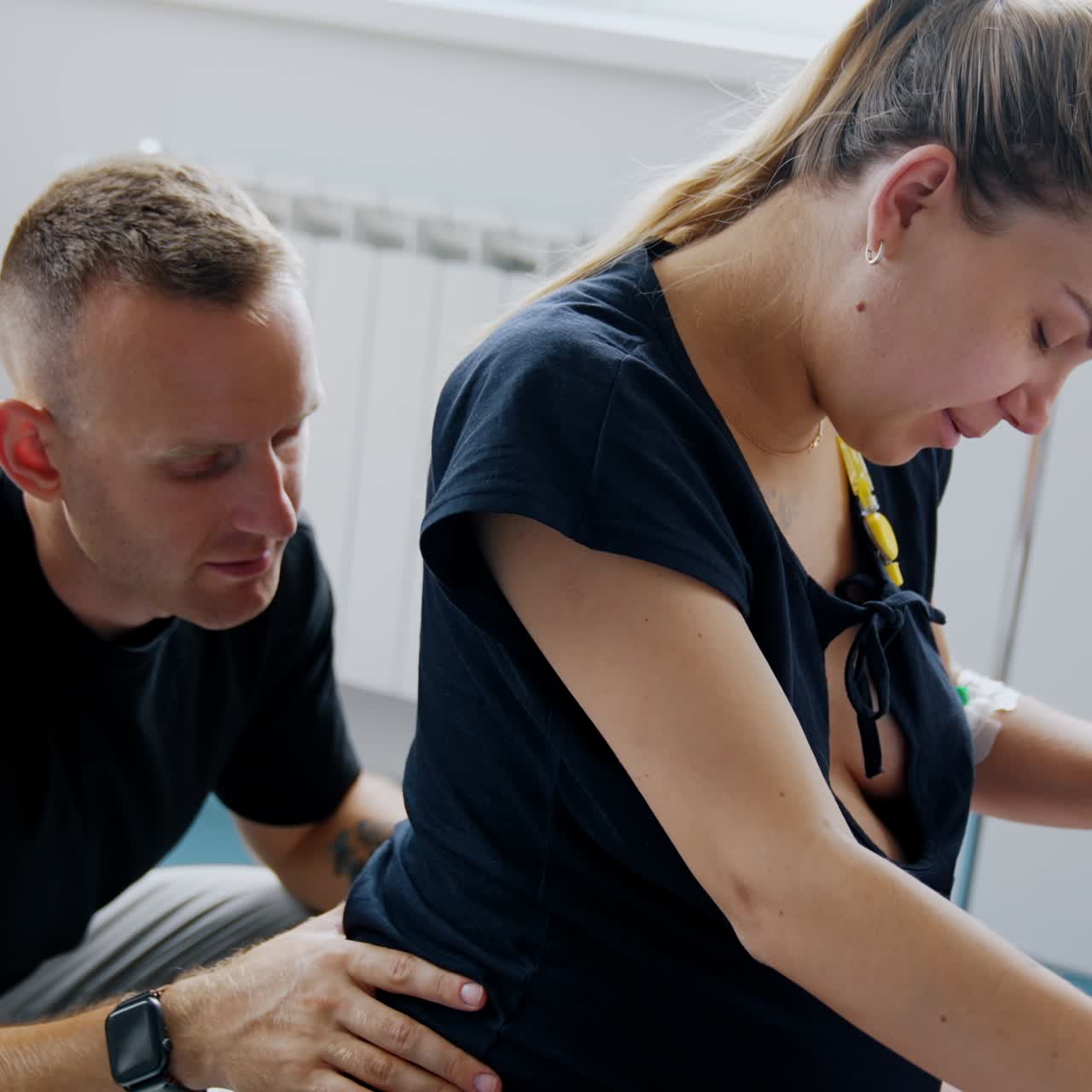 Expecting couple going through the painful contractions. Man is aiding massaging wife's lower back