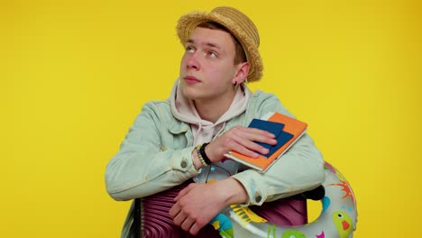 displeased tired boring traveler tourist teen stylish man in summer clothes on yellow background