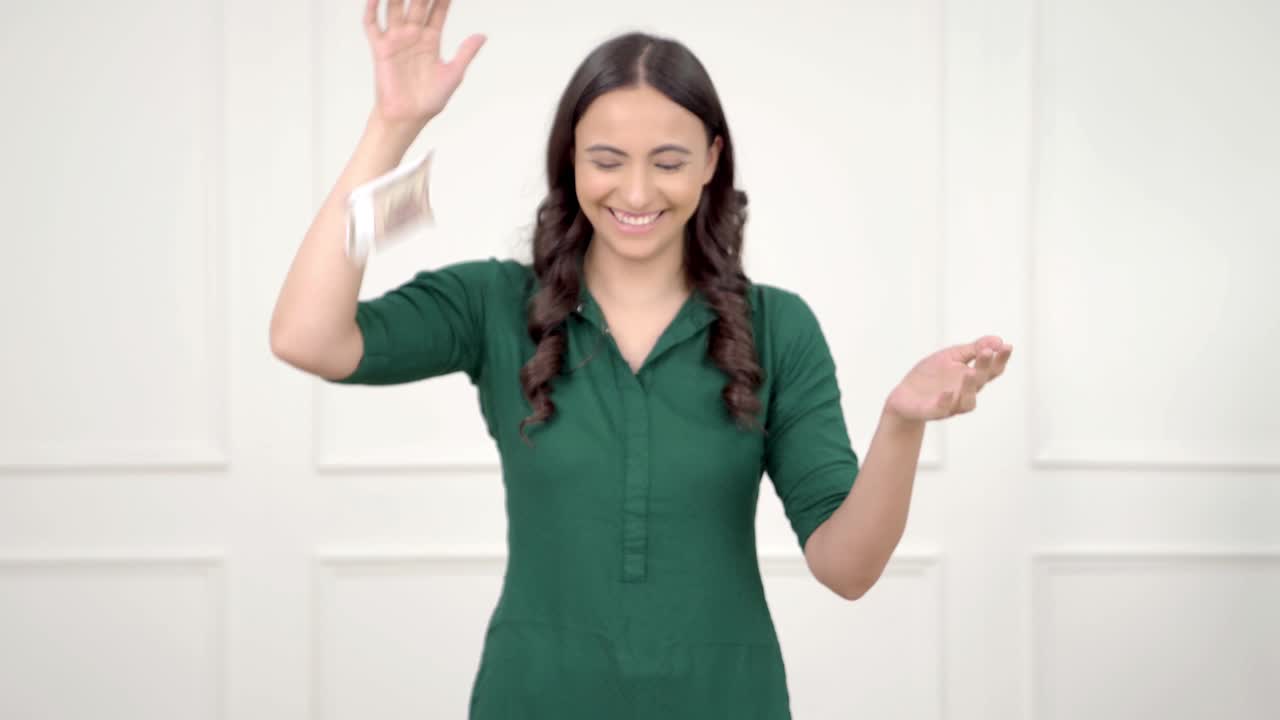 chica india rica lanzando dinero en el aire