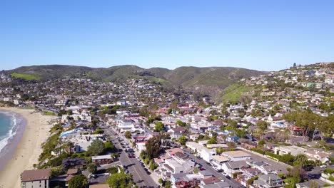 Aerial-View-of-Downtown-Laguna-Beach,-California-with-Panning-Views-of-the-Crystal-Clear-Pacific-Ocean-on-a-Warm,-Sunny-Day