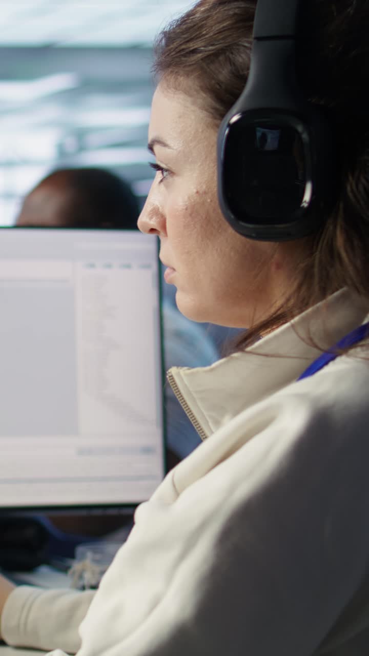 Programmatrice che lavora al computer e indossa le cuffie in ufficio