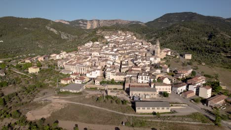 Vista-Aérea-Lenta-Que-Se-Acerca-A-Un-Pequeño-Pueblo-Entre-Montañas-En-Una-De-Las-Regiones-Rurales-Vacías-De-España-En-Aragón,-España