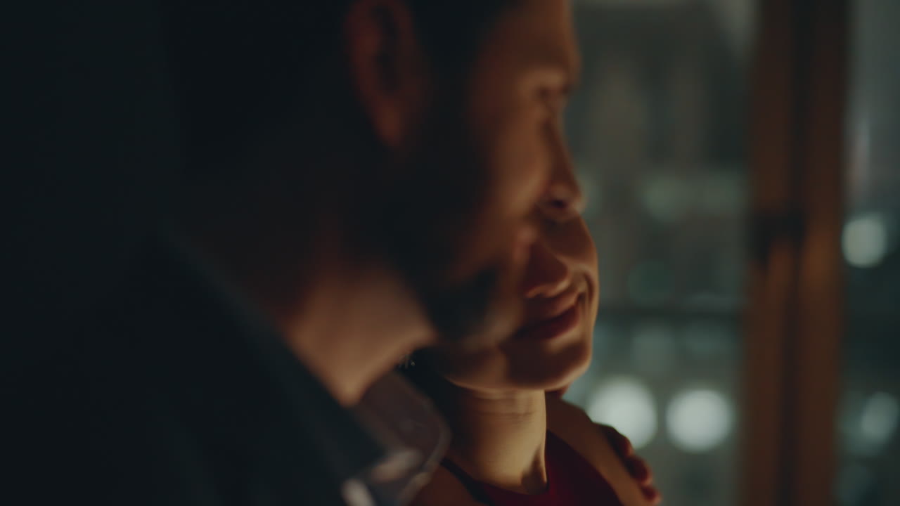 밤의 창문에서 가까이 쳐다보는 여자 로맨틱한 남자가 사랑하는 아내를 포옹하고