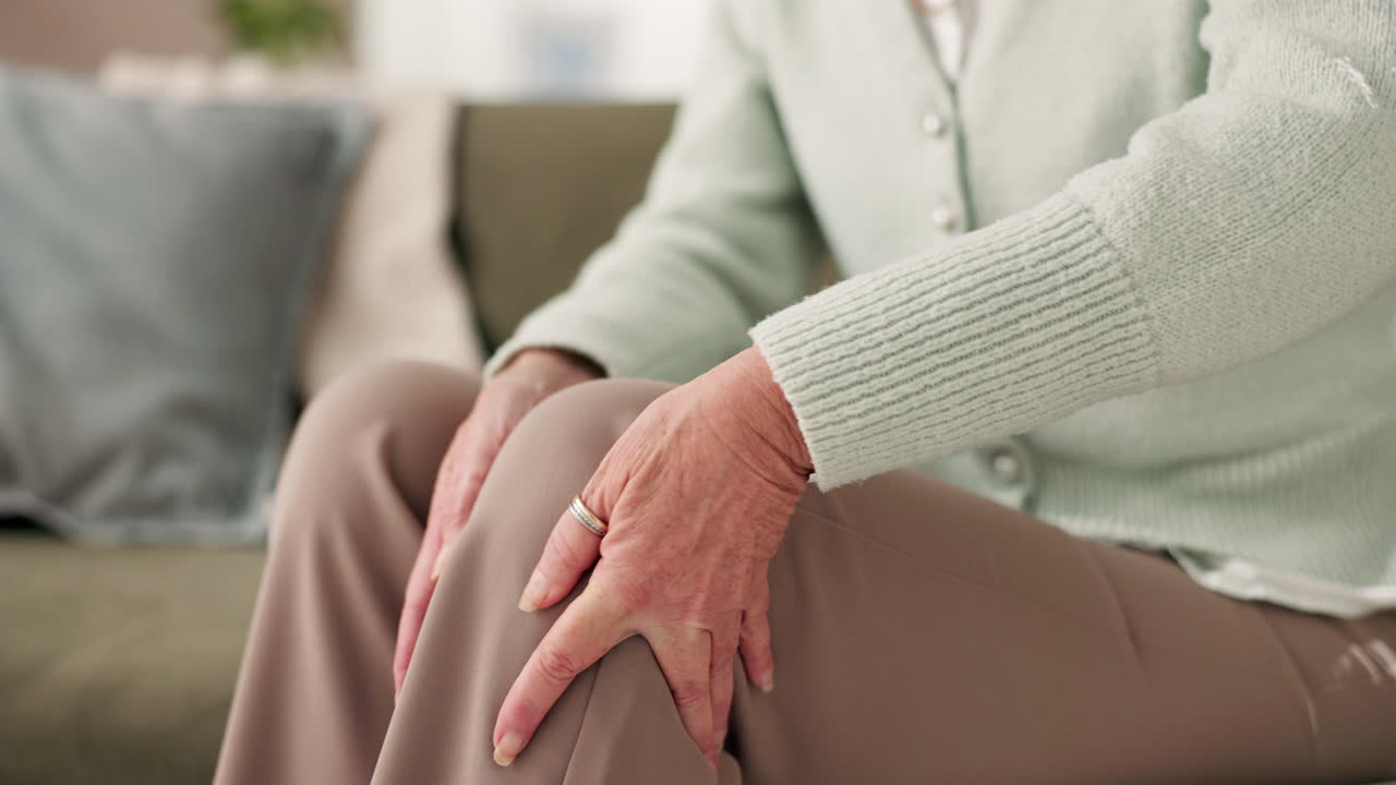 Elderly woman sitting on sofa with hands on knee