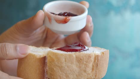 person spreading jam on bread