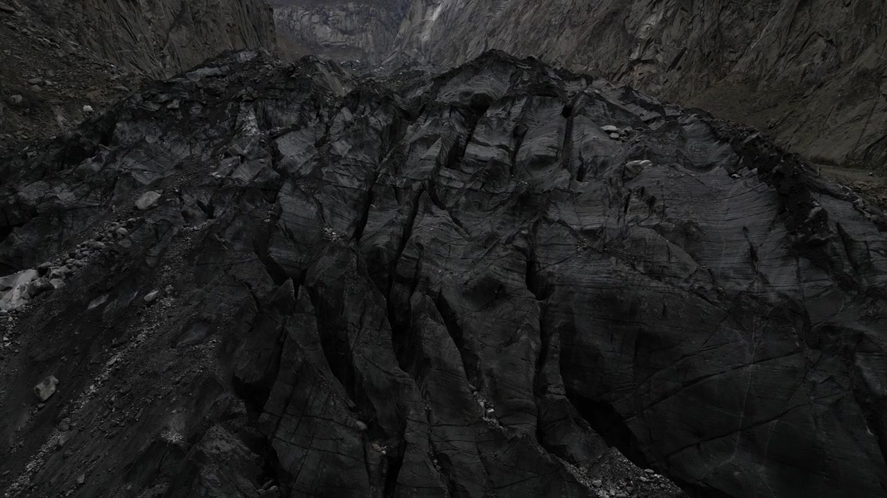 Volo di drone sopra la rocciosa Valle del Ghiacciaio di Karimabad nella regione di Hunza, Pakistan, che rivela un aspro terreno montuoso e un paesaggio glaciale. Riprese aeree di viaggio panoramiche