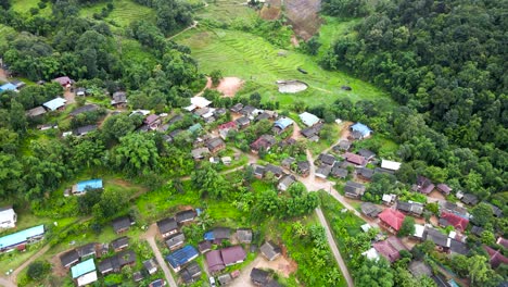 vuelo aéreo sobre la aldea de la tribu karen en chiang mai y granjas en terrazas en la ladera