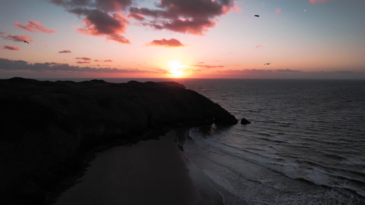 AERIAL: Sunset reveal over beach with sea birds, Blue Pool Bay, 4k Drone