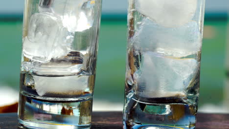 pouring water into glasses with ice