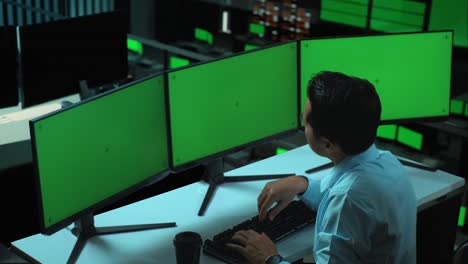 vista lateral de un hombre asiático cansado bostezando mientras trabaja con múltiples monitores de computadora simulados en la oficina