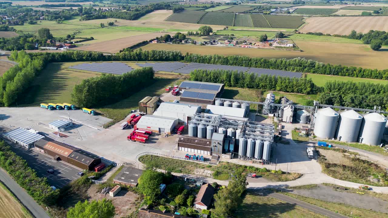 Dolly-Schwenk nach rechts: Drohnenansicht einer industriellen Verarbeitungsanlage mit Silos in der Landschaft von Kent.