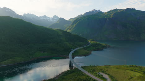 Sunlight-streams-through-mountains-above-Austerstraumen-and-Vesterstraumen-bridges,-Lofoten-Norway