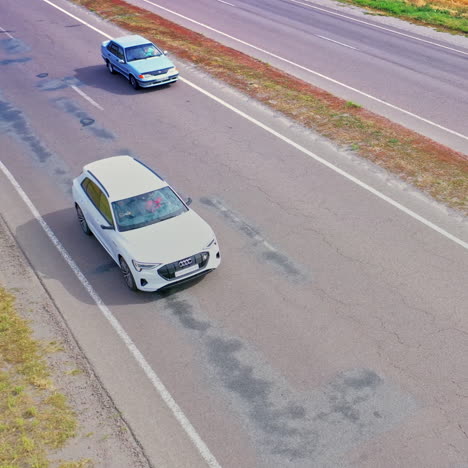 view from above on luxury white car on the highway. beautiful audi driving along the road among yellow fields. aerial view.
