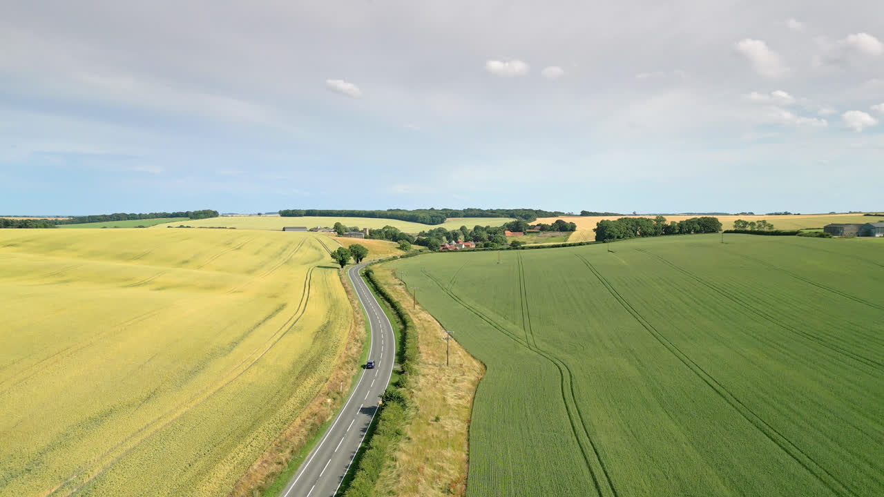 Drone footage of Lincolnshire countryside, peaceful scene of farms, fields, wheat, barley, road