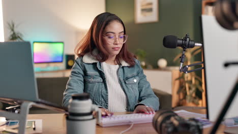 woman working at a desk with computer, microphone and camera