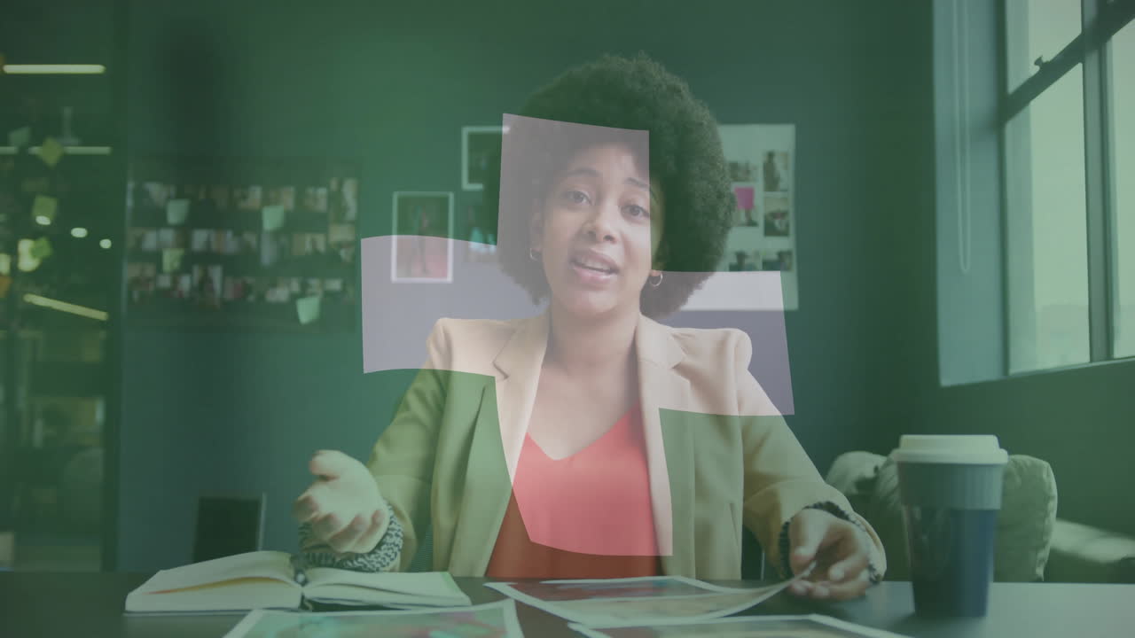 Discussing ideas, businesswoman with green cross animation overlay in office setting