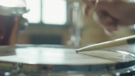 drumsticks hitting head of drum