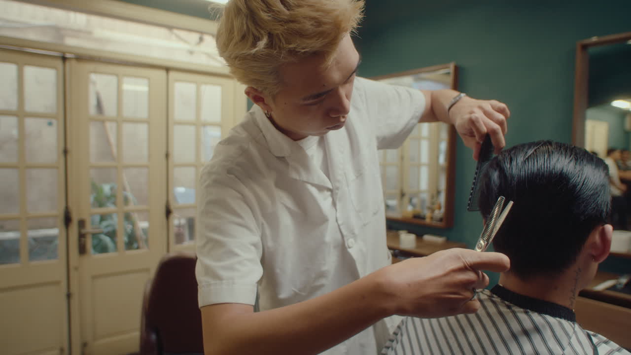 Asian Barber Using Thinning Scissors Giving Haircut to Client