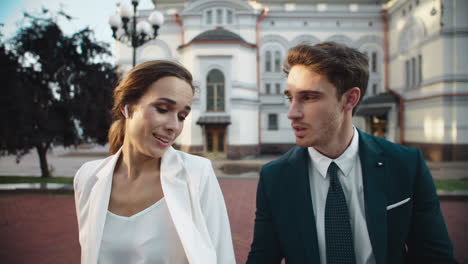 charming business man and female professional talking about documents outdoors