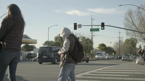 people standing by for the light at an intersection