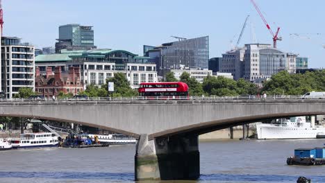 a red bus crosses a bridge in london