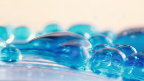 blue liquid bubbles sliding down surface