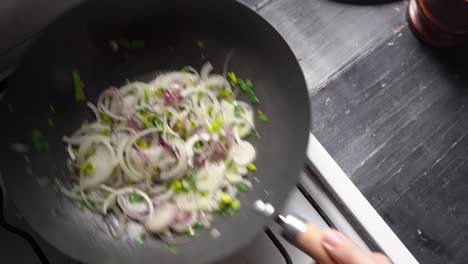 persona agitando pan con cebolletas con cebollas blancas